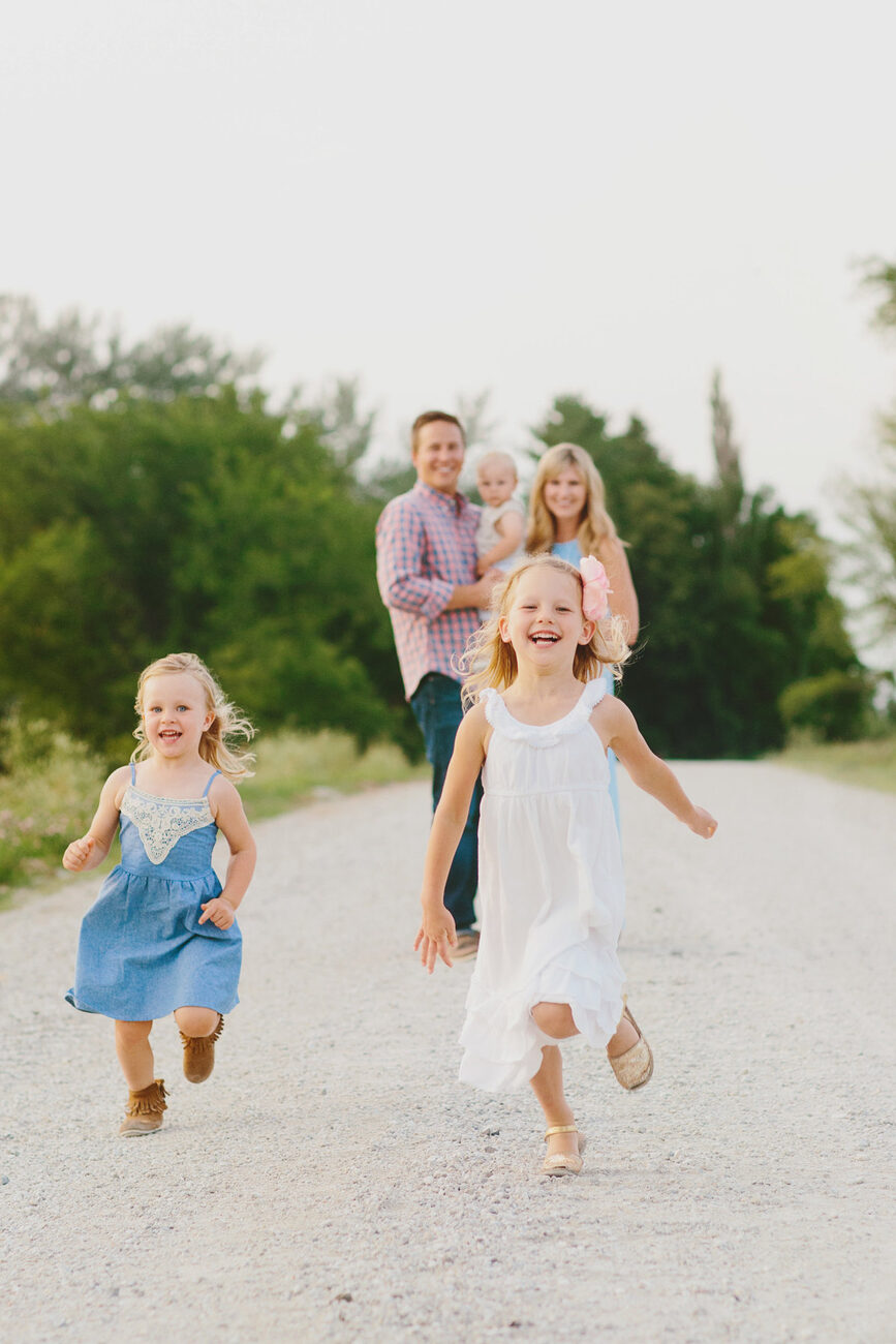 Kids running ahead of parents down country road, candid Boise family photographer
