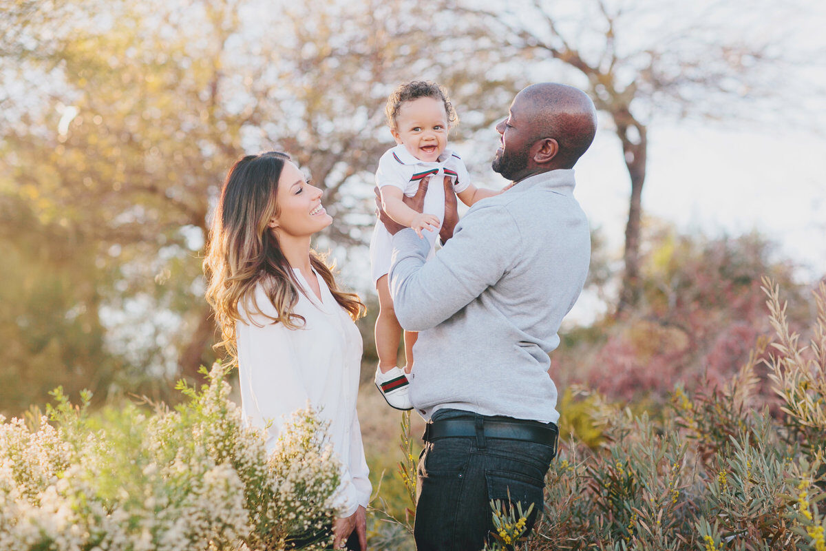 Parents holding baby among autumn trees, on-location Boise family photography