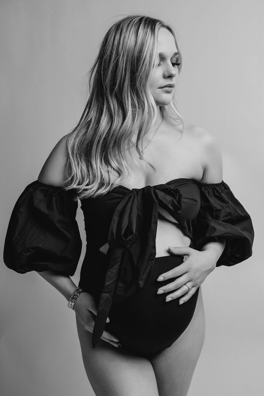 Editorial maternity portrait in black puff-sleeve bodysuit, Boise maternity photography studio
