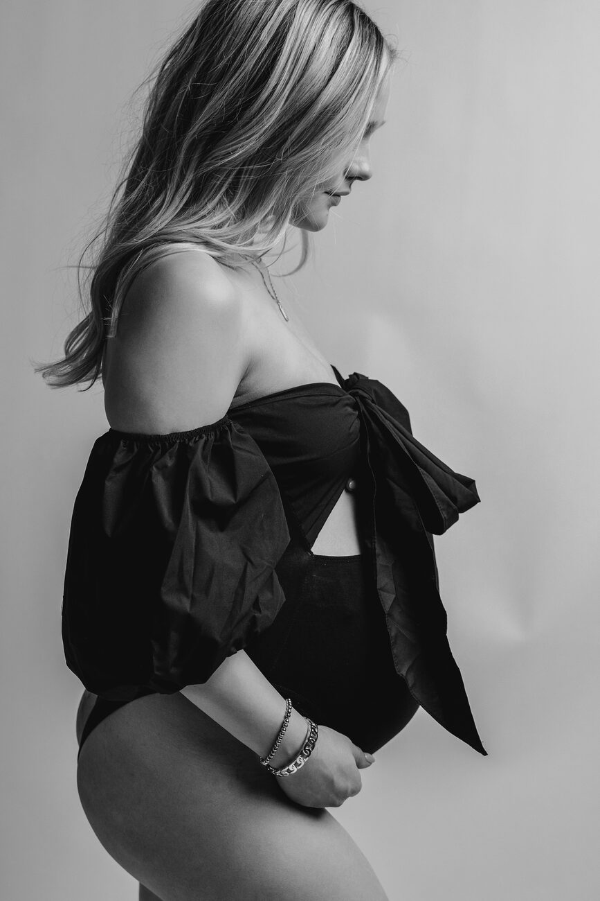 Profile maternity portrait in black off-shoulder bodysuit with bow, Boise maternity session