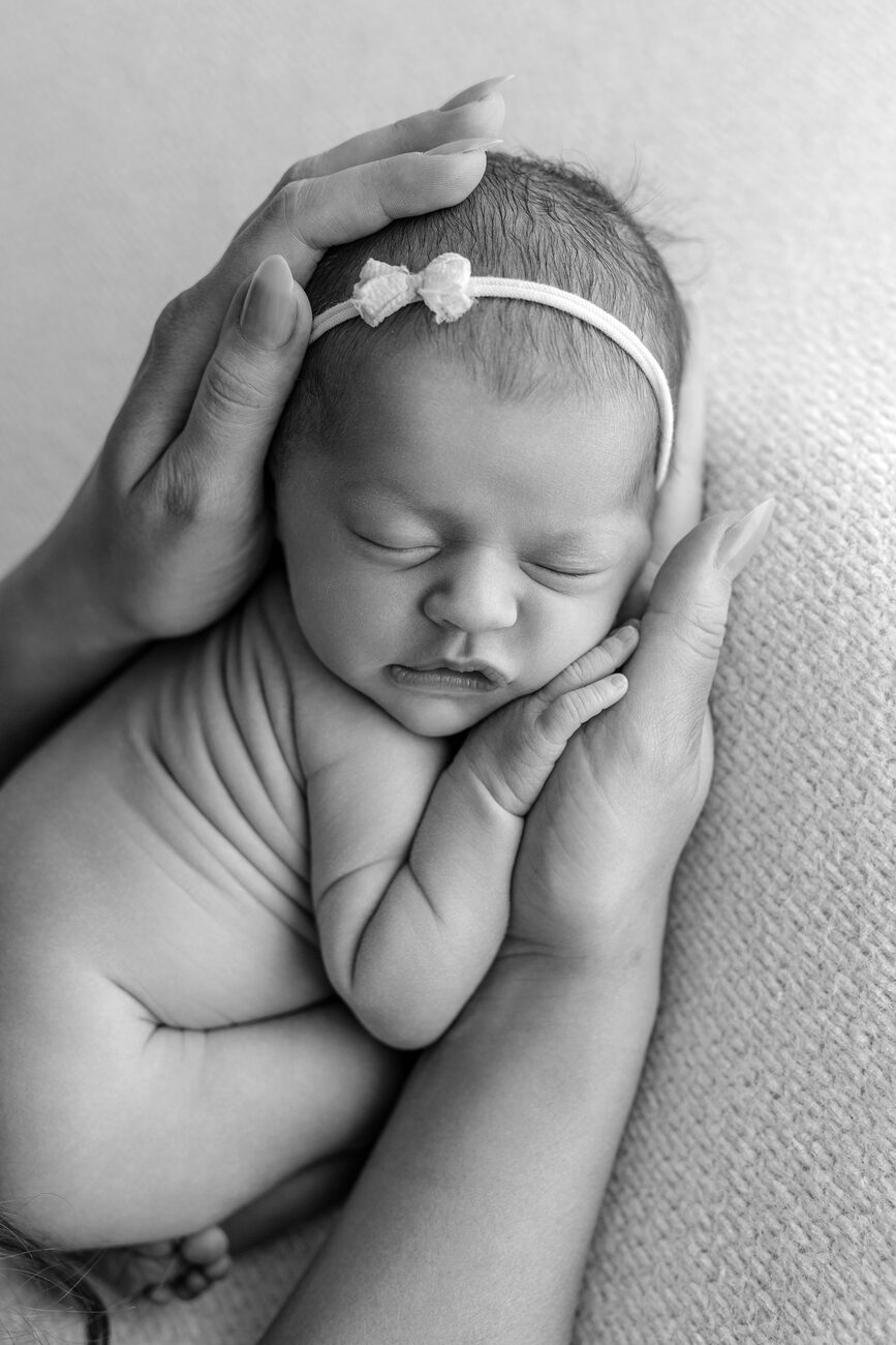 Mother’s hands cradling her sleeping newborn’s face, black and white Boise newborn photos