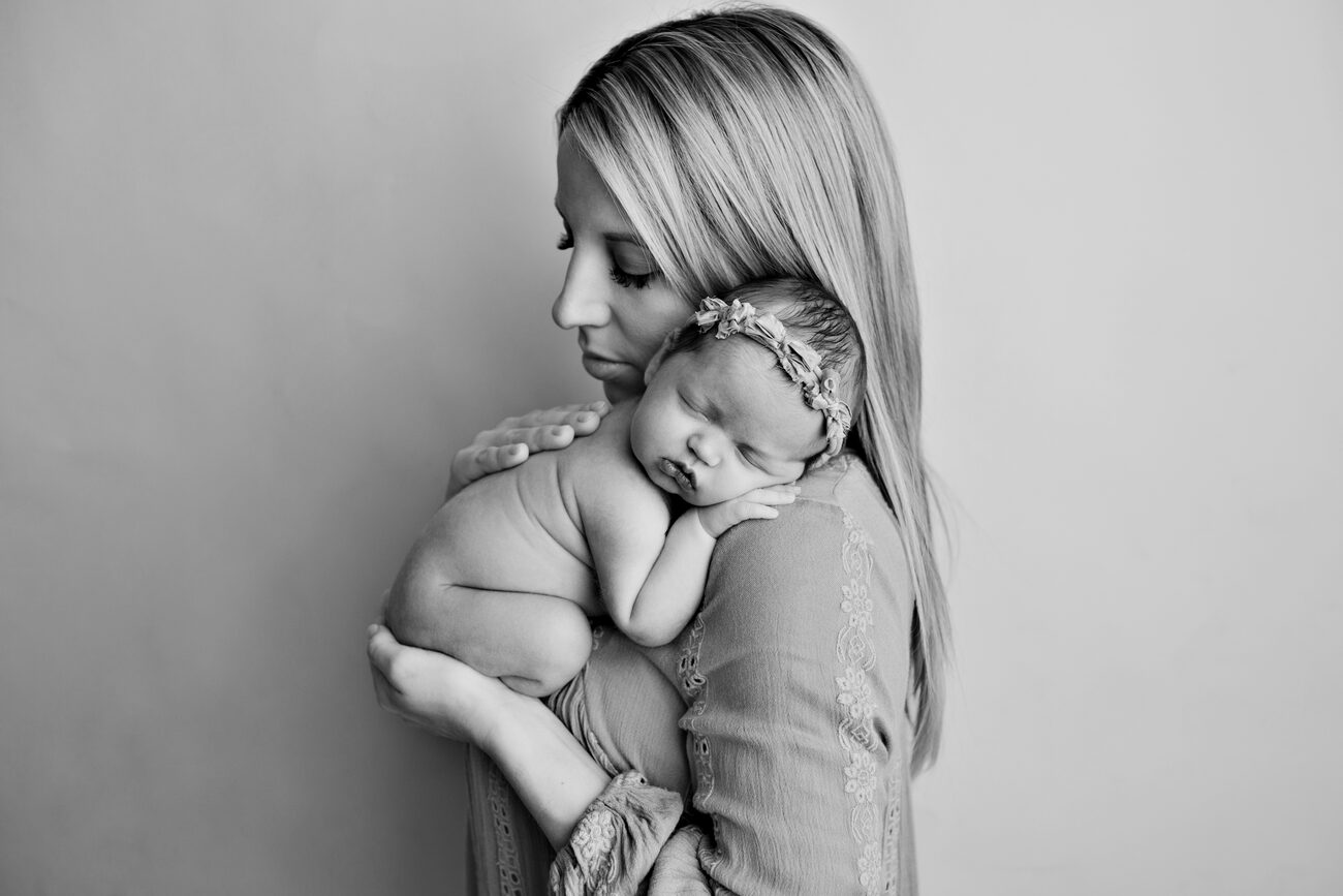 Mother holding her newborn daughter on her shoulder, black and white Boise newborn portrait
